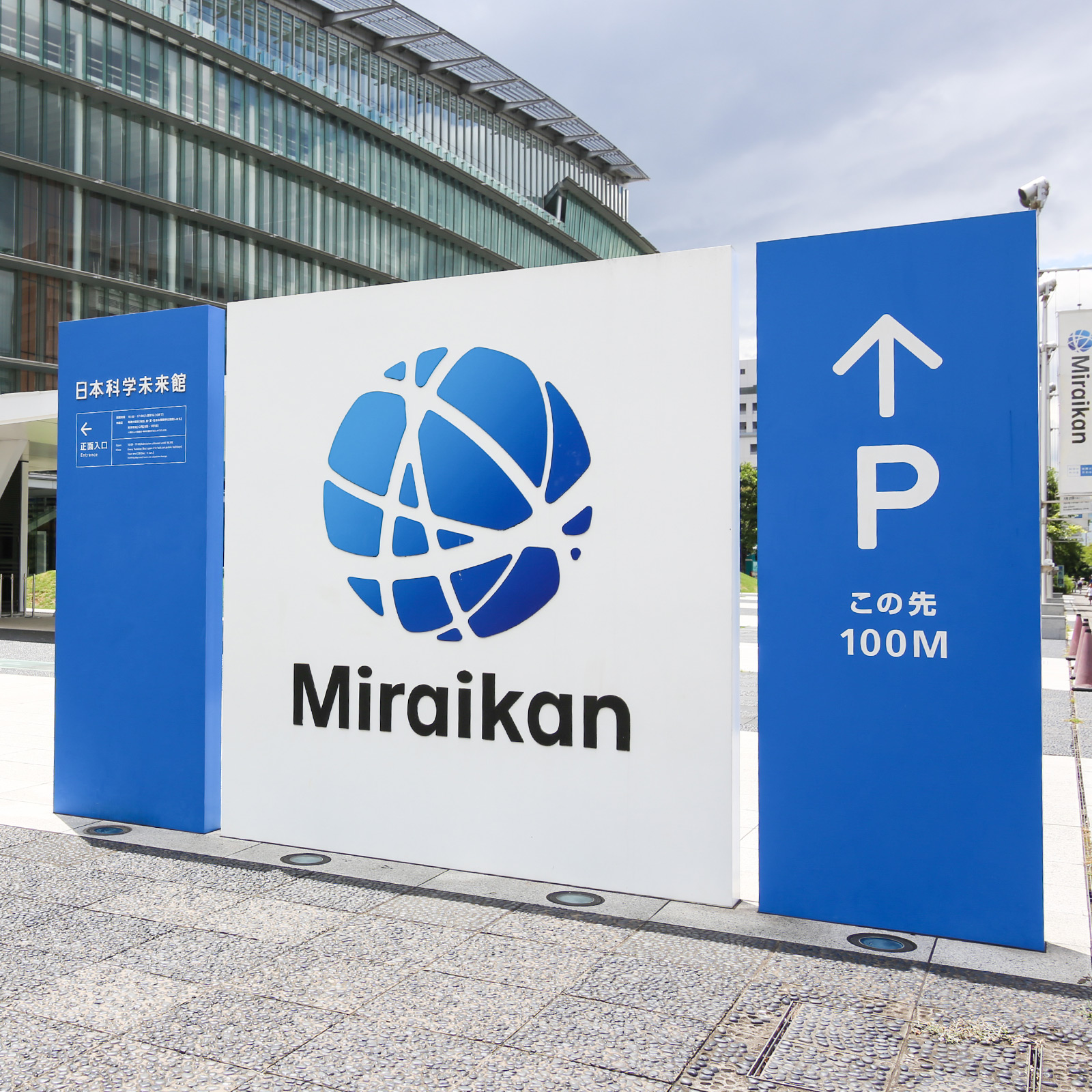 Miraikanの愛称と青いシンボルマーク。地球と衛星軌道、細胞分裂、人と人、人と情報といった地球上のさまざまなネットワーク、電子の動きなどをイメージさせる。